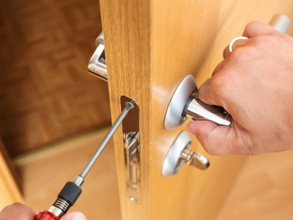 Chaveiro a instalar fechadura nova em porta residencial